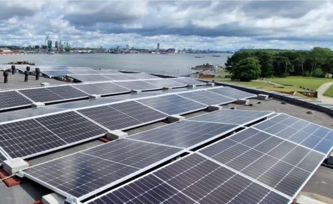 Saulės elektrinė ant pastato stogo – sumontuoti saulės moduliai gamina elektros energiją iš saulės